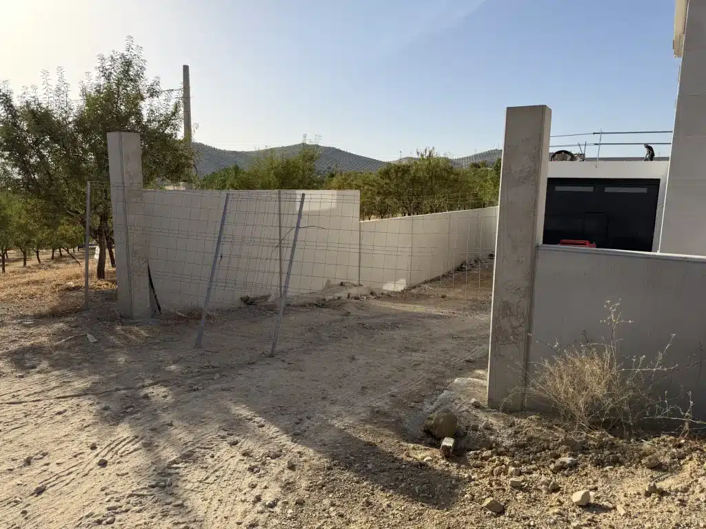 Muro prefabricado de hormigón cerrando una finca de olivar — Los Cahices, Granada