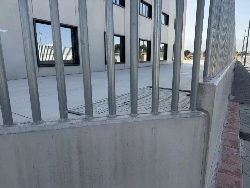 Celosía de lamas verticales de hormigón prefabricado en fachada de nave industrial — Los Cahices, Granada
