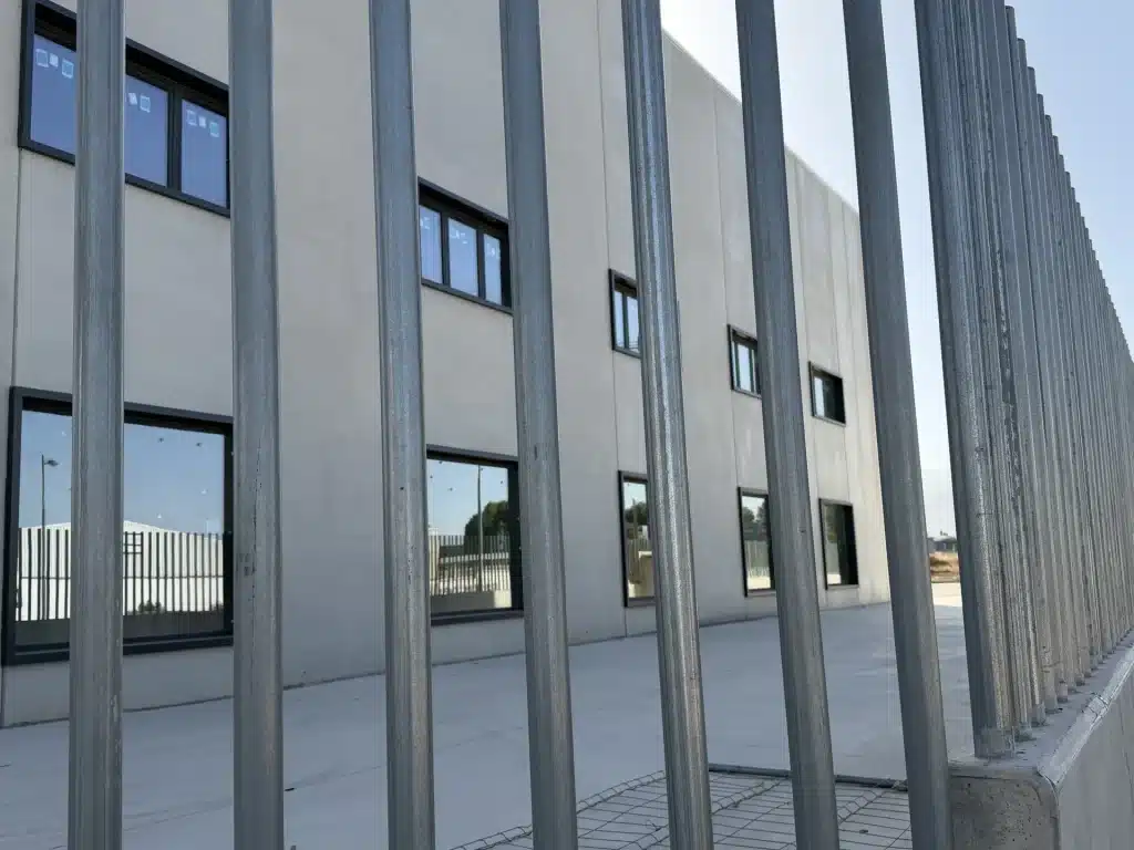 Celosía de lamas verticales de hormigón prefabricado en fachada de nave industrial — Los Cahices, Granada