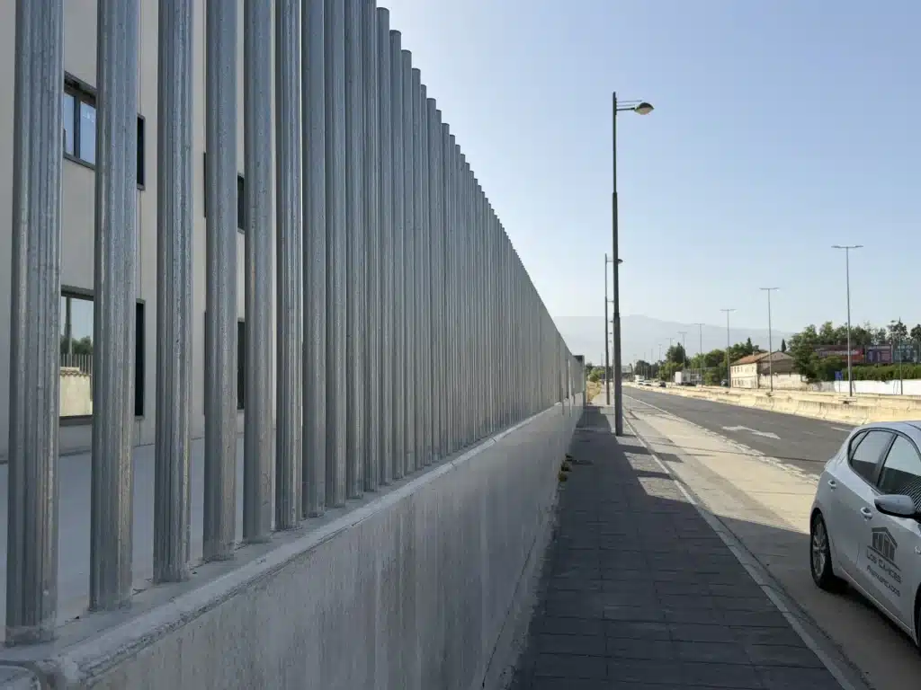 Celosía de lamas verticales de hormigón prefabricado en fachada de nave industrial — Los Cahices, Granada