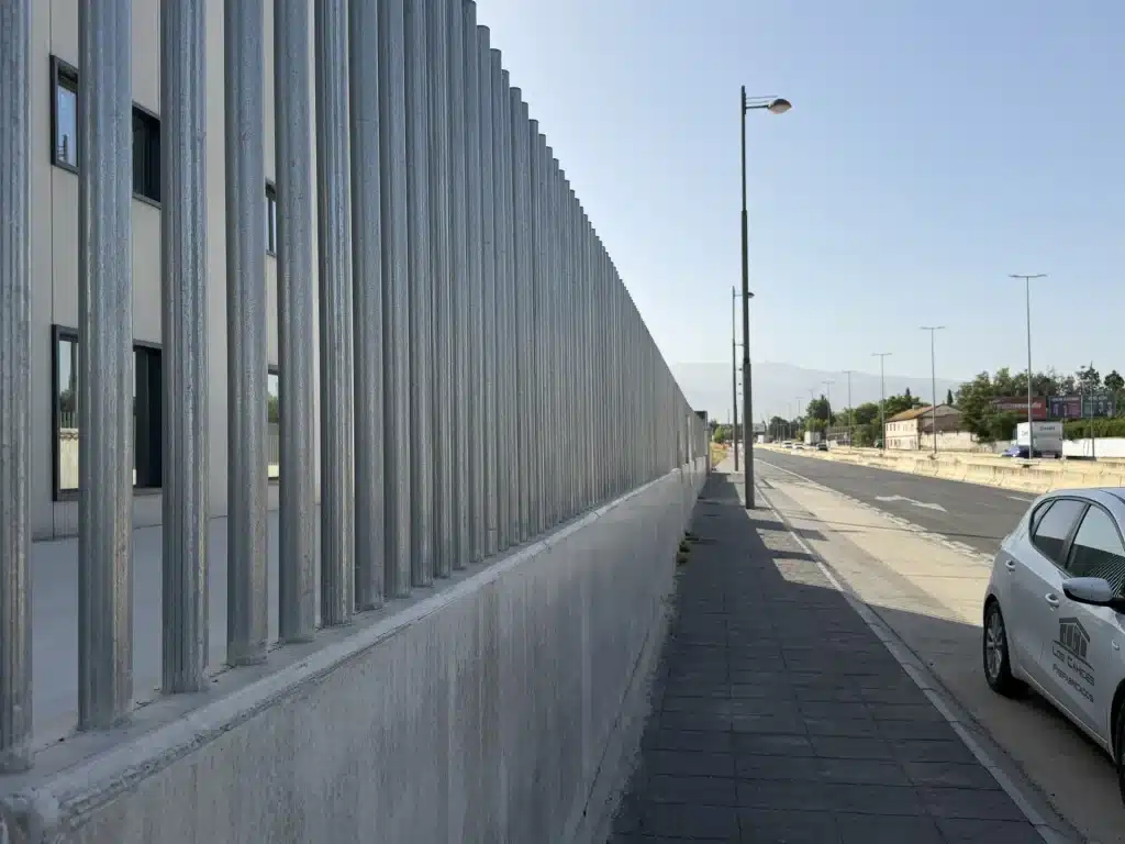 Celosía de lamas verticales de hormigón prefabricado en fachada de nave industrial — Los Cahices, Granada
