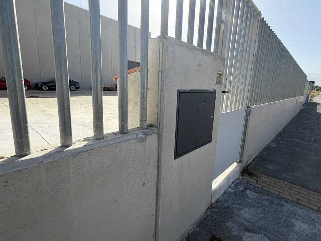 Celosía de lamas verticales de hormigón prefabricado en fachada de nave industrial — Los Cahices, Granada