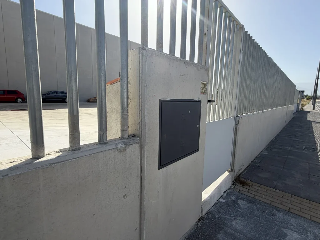 Celosía de lamas verticales de hormigón prefabricado en fachada de nave industrial — Los Cahices, Granada