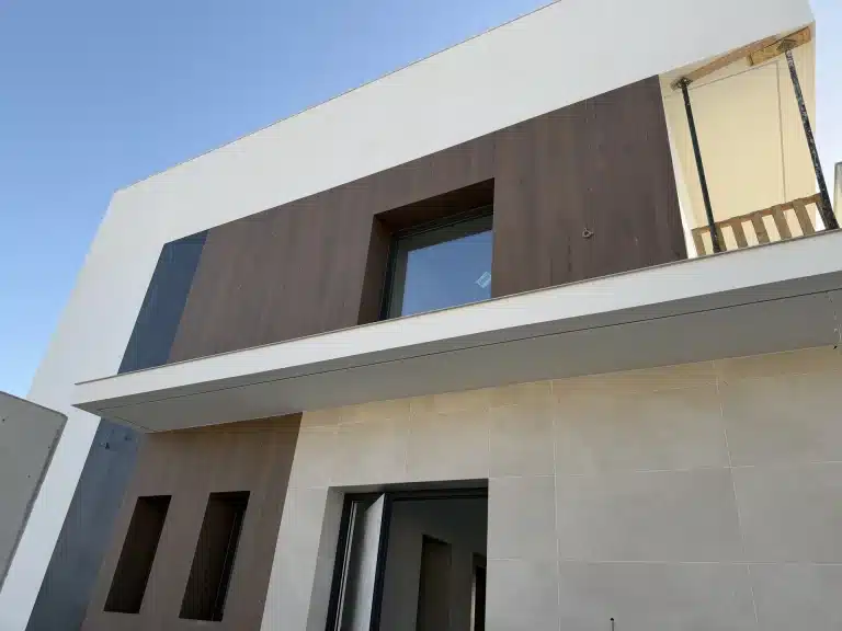 Fachada de vivienda en panel de hormigón prefabricado con celosía de madera — Los Cahices, Granada