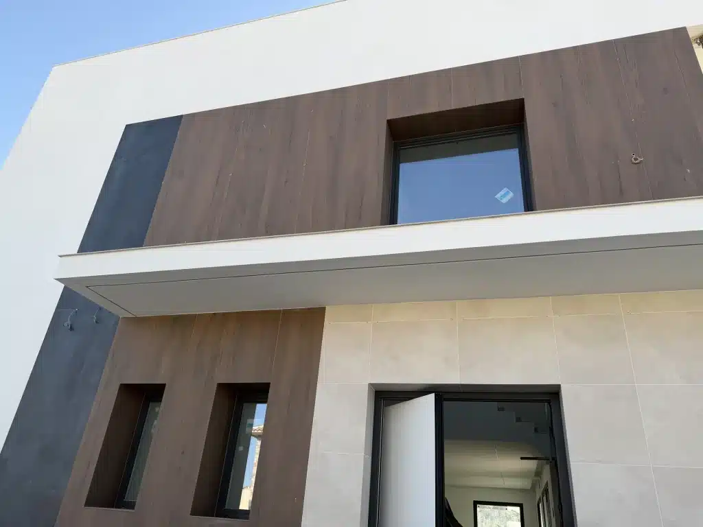 Fachada de vivienda en panel de hormigón prefabricado con celosía de madera — Los Cahices, Granada