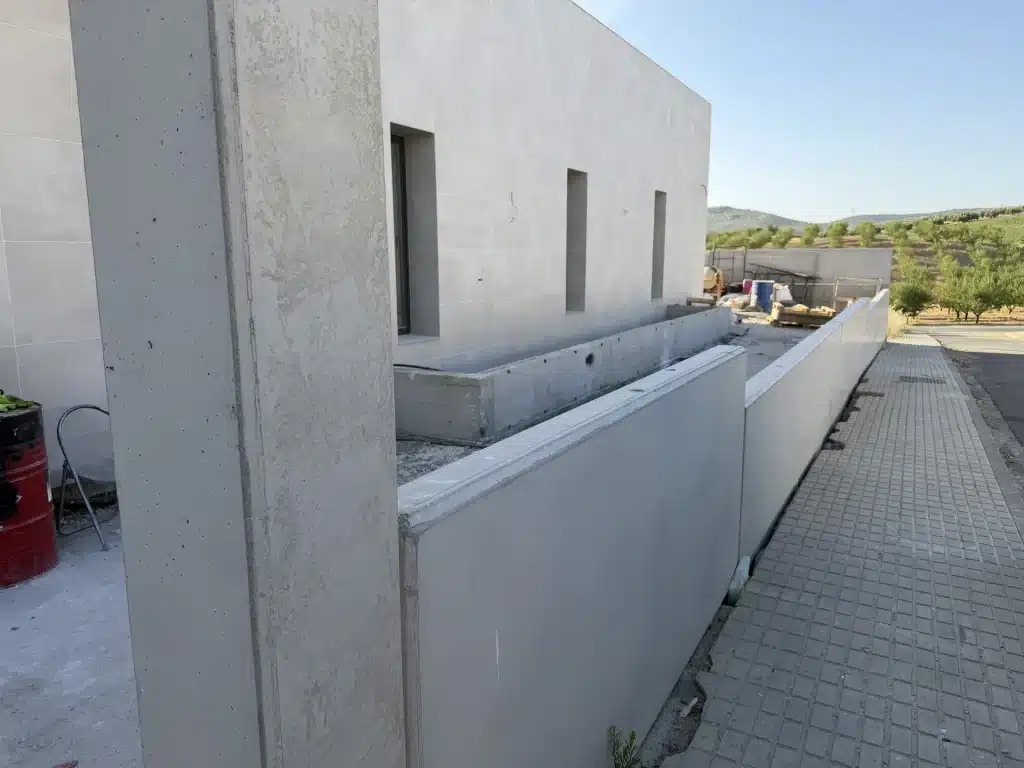Fachada de vivienda en panel de hormigón prefabricado con celosía de madera — Los Cahices, Granada