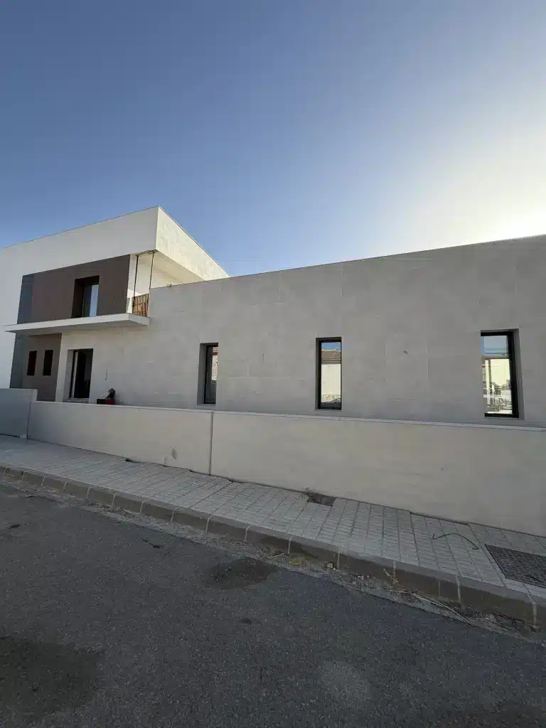 Fachada de vivienda en panel de hormigón prefabricado con celosía de madera — Los Cahices, Granada
