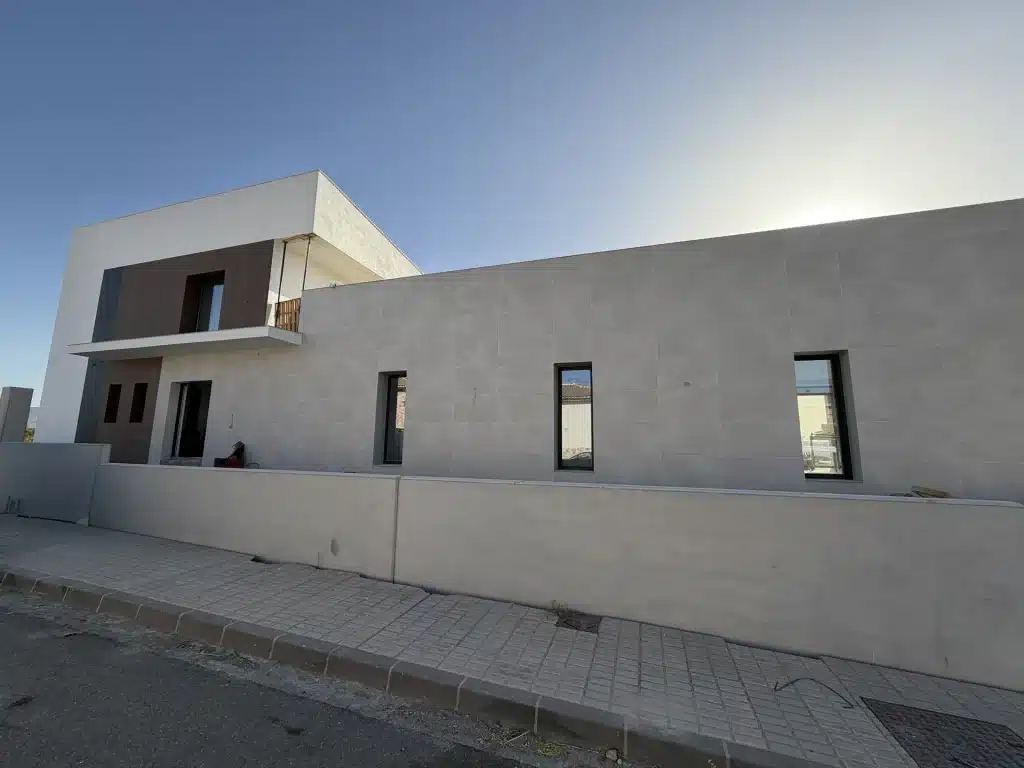 Fachada de vivienda en panel de hormigón prefabricado con celosía de madera — Los Cahices, Granada