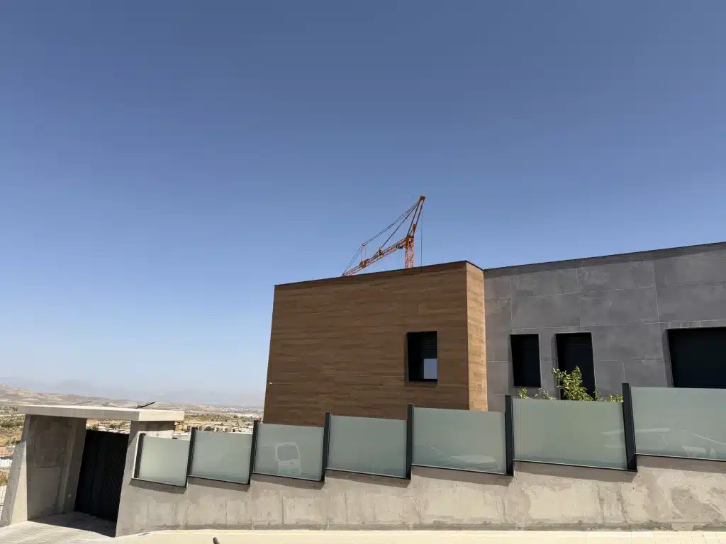 Fachada de vivienda en panel de hormigón prefabricado con celosía de madera — Los Cahices, Granada