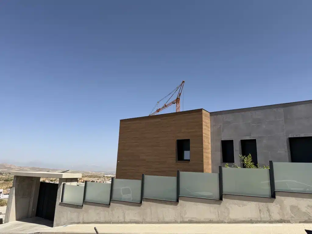 Fachada de vivienda en panel de hormigón prefabricado con celosía de madera — Los Cahices, Granada