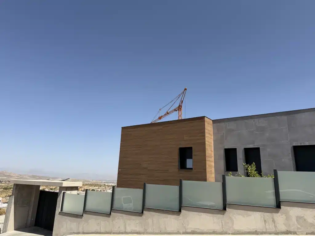 Fachada de vivienda en panel de hormigón prefabricado con celosía de madera — Los Cahices, Granada